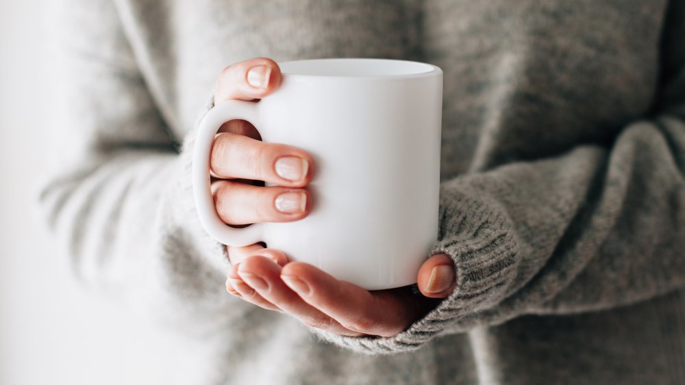 a woman holding a mug of tea