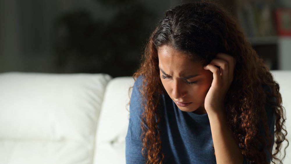 A depressed woman sitting on a couch