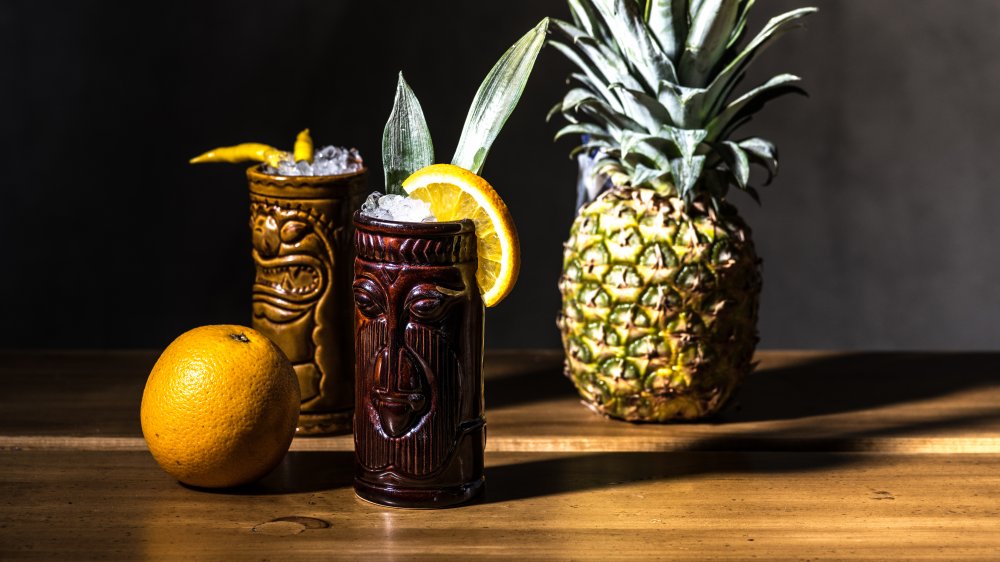 Tiki drinks made with rum on a bar with fruit