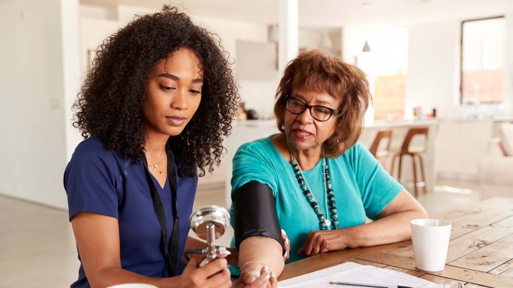 A doctor checking her patient's blood pressure