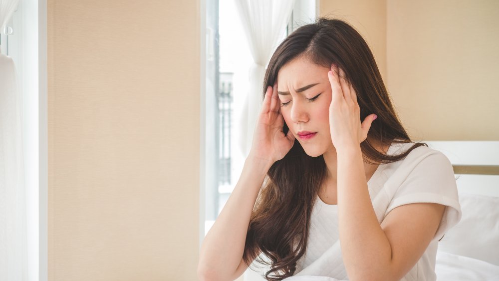 A woman in bed with a hangover after drinking rum