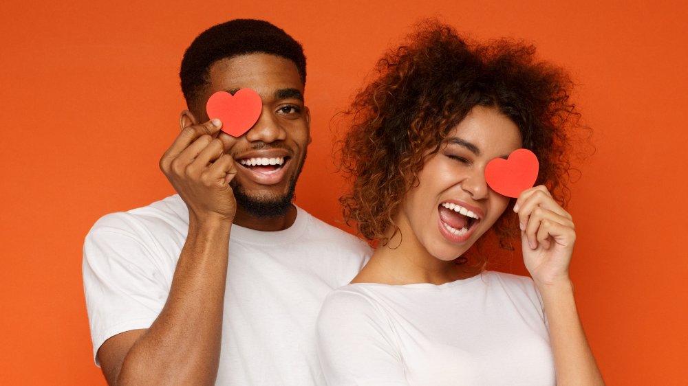 A couple holding paper hearts, heart health concept