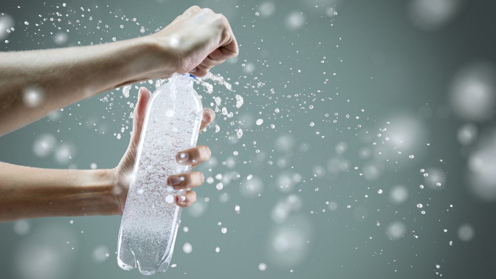 A woman's hands opening a bottle of sparkling water