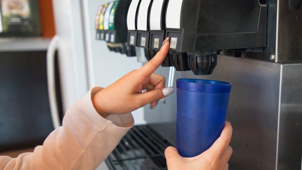 A woman's hands about to pour seltzer water into a cup