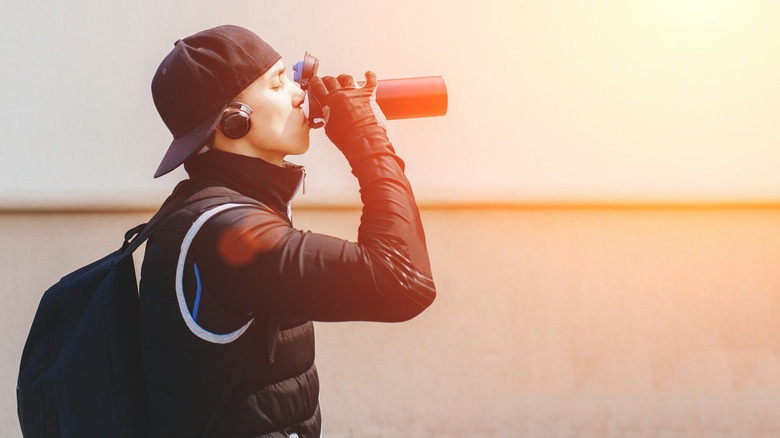 an athletic man drinking water