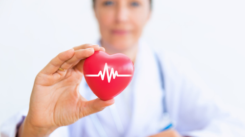 female doctor holding heart prop