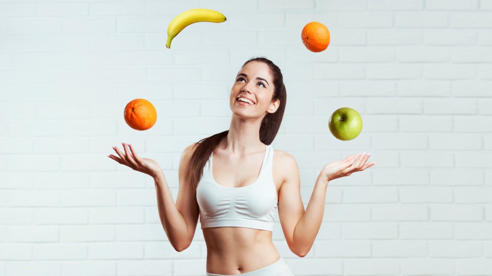 Woman juggling banana and other fruit