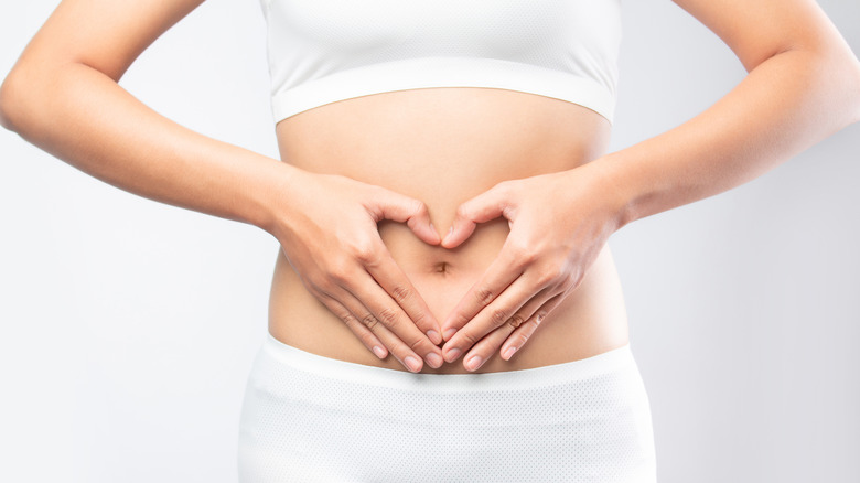 Woman making heart on stomach