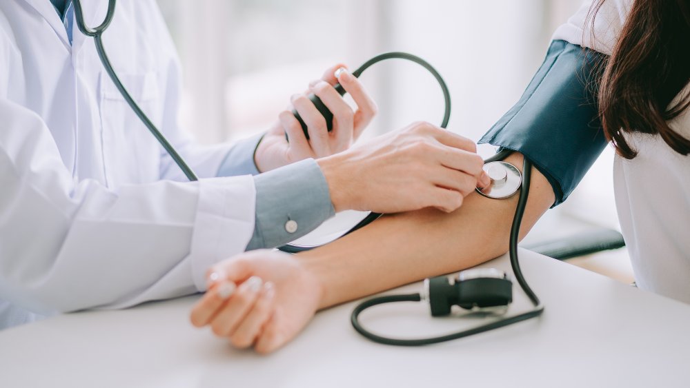 A doctor checking a patient's blood pressure