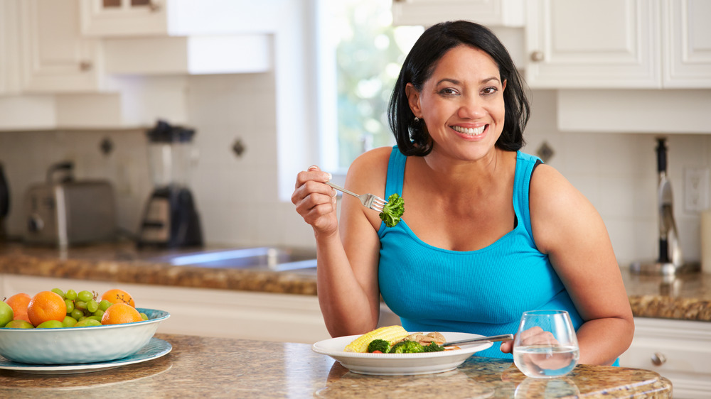 Woman eating chicken and veggies