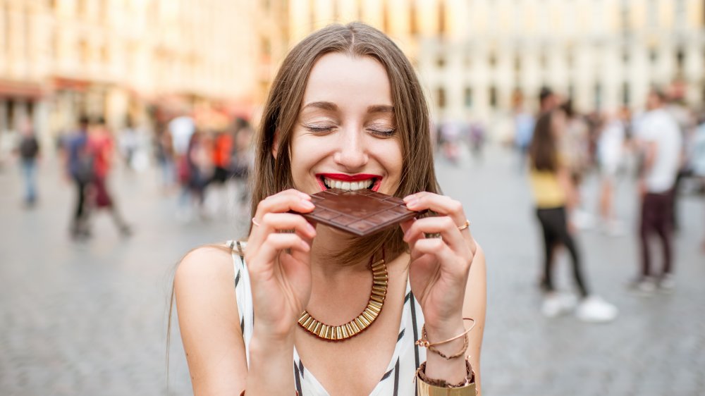 woman eating a bar of chocolate