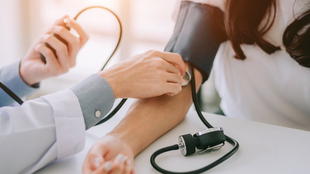 Doctor checking blood pressure