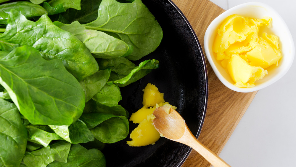 Fresh spinach leaves and ghee in the cooking pan