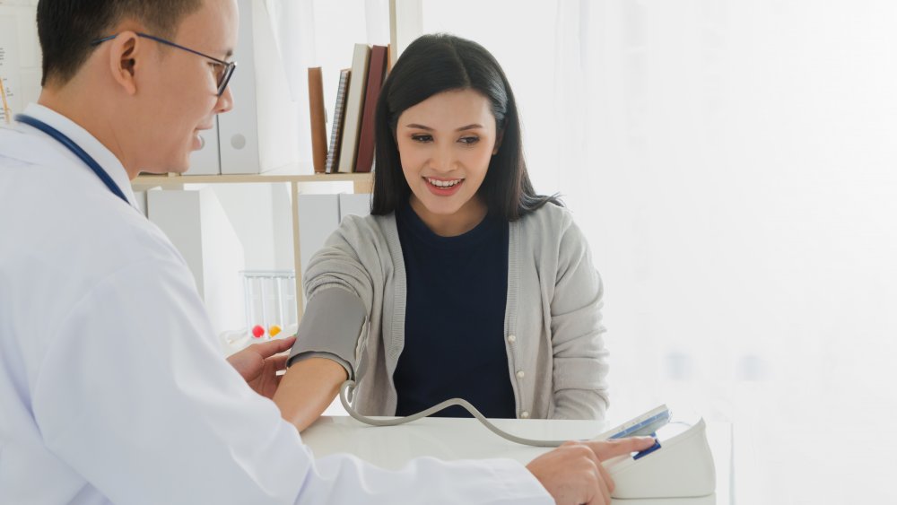 A doctor checking a woman's blood pressure