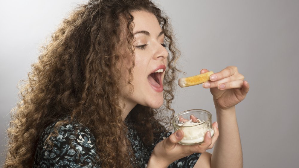 woman eating fries and mayonnaise