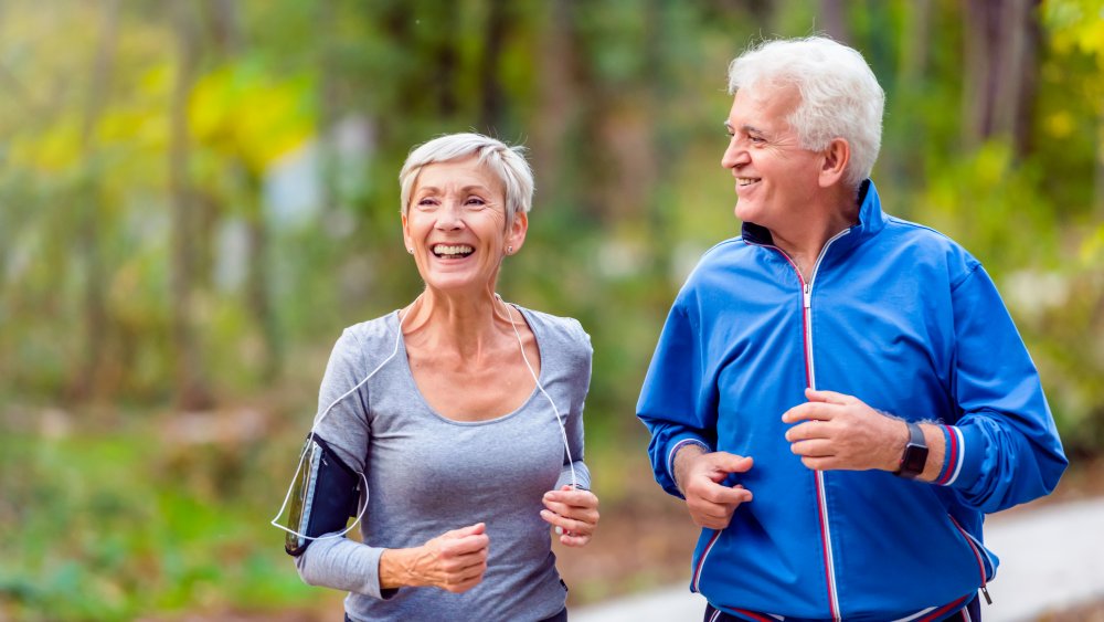 A happy senior couple jogging