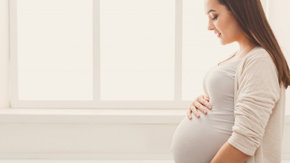 A pregnant woman touching her belly