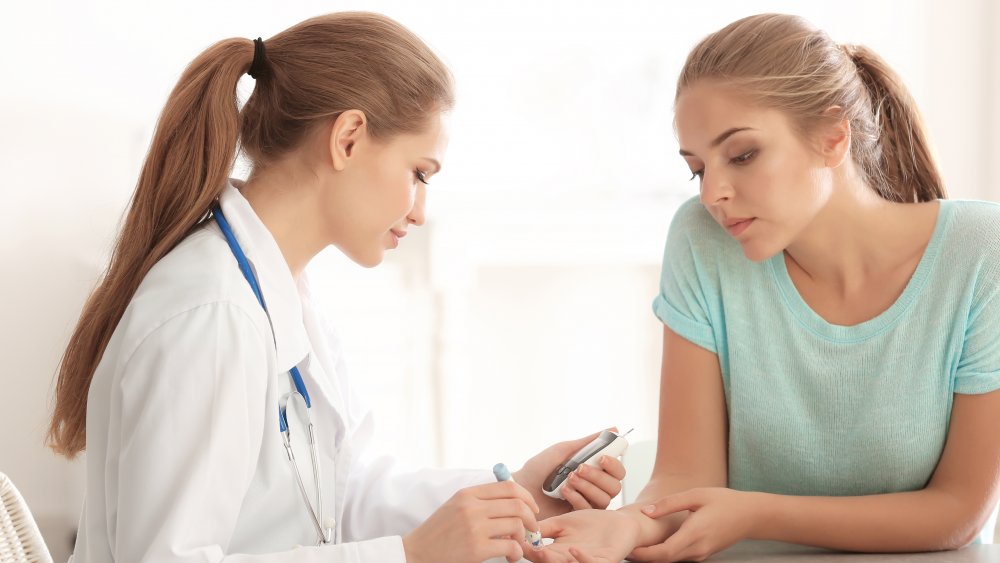 A doctor checking a woman's blood pressure