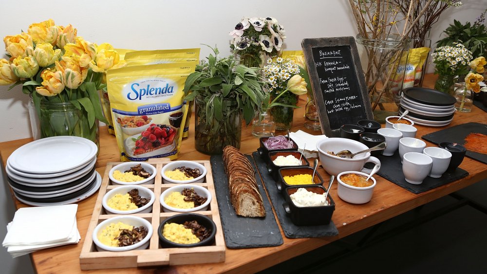 A table with Splenda, flowers, and baked goods