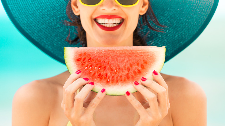 Woman smiling and eating watermelon