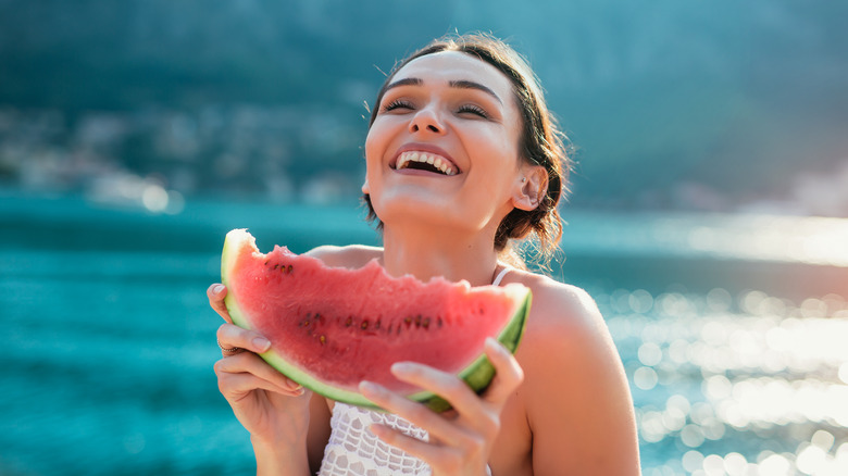 Happy woman eating watermelon