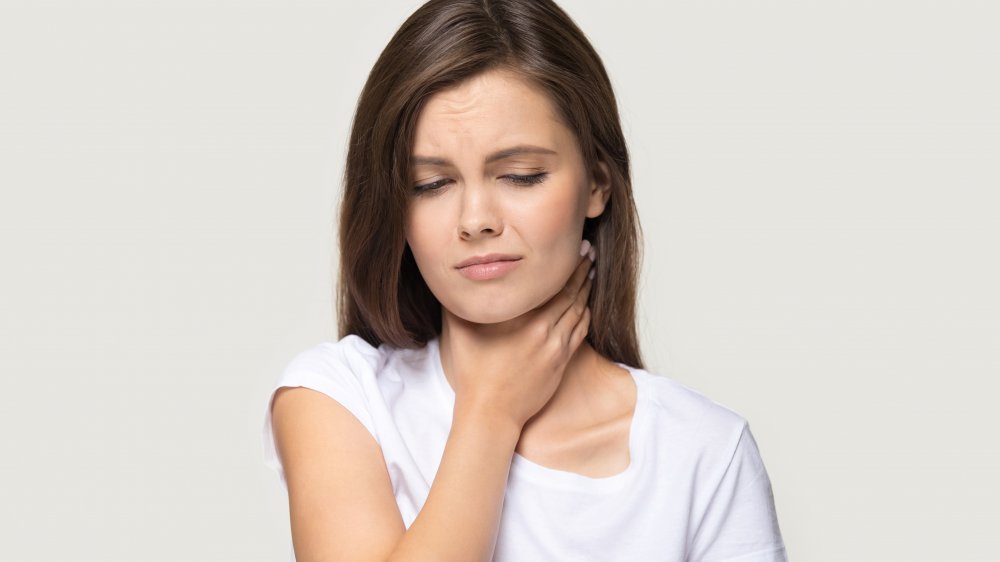 woman with a sore throat, a symptom of coronavirus