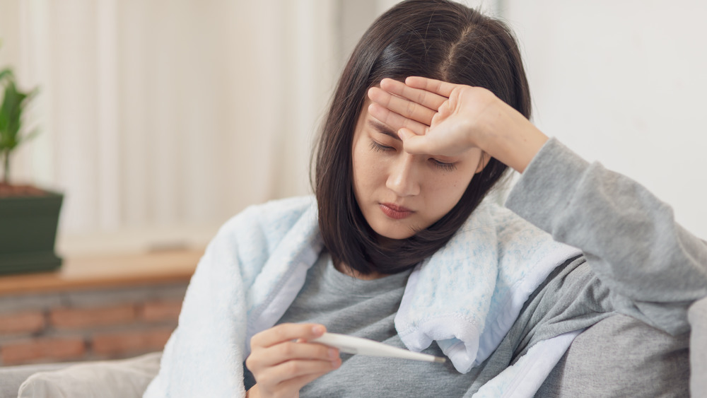 A woman taking her temperature