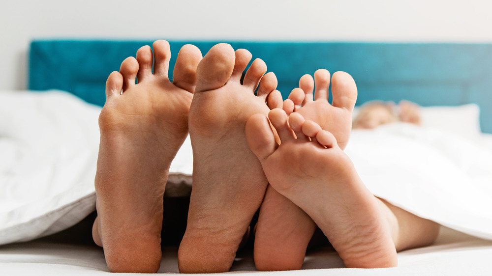 A couple's feet in bed