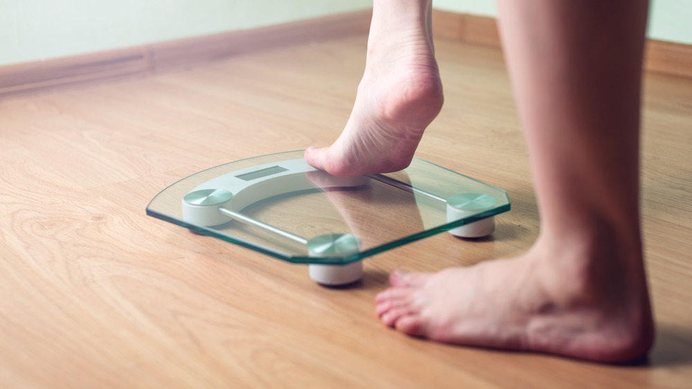 A woman stepping onto a scale