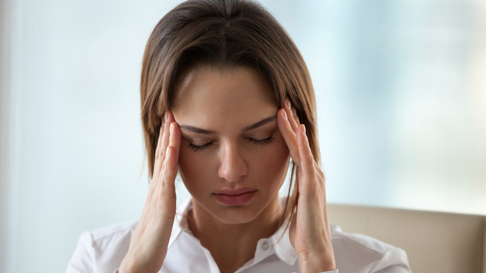 woman with a hangover holding her head