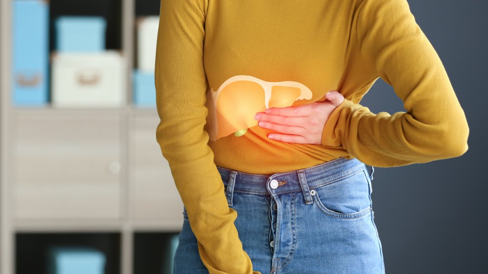 woman holding stomach where liver is