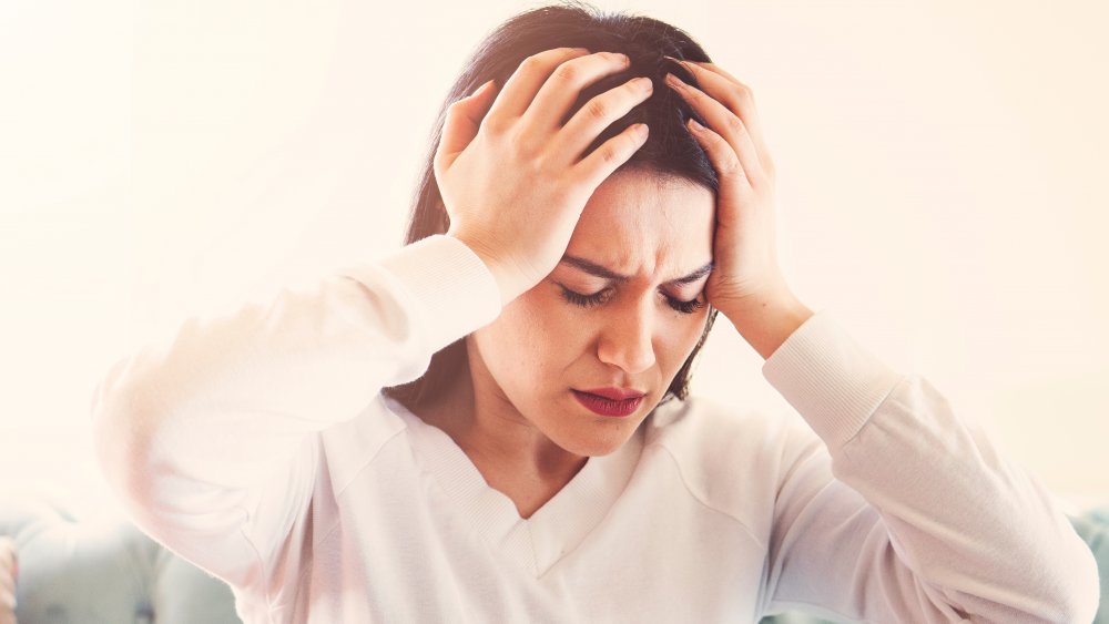 a woman with a hangover holding her head