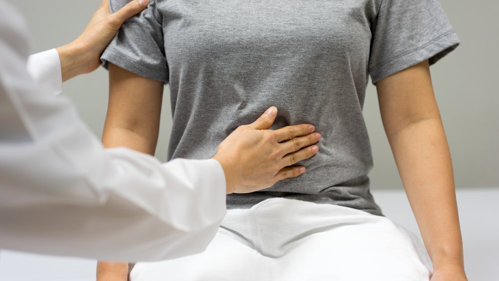 Doctor examining woman's abdomen 