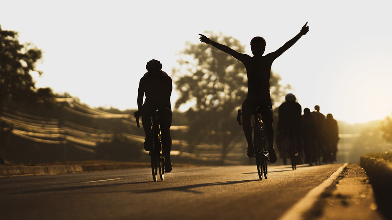 People in sillouhette cycling together 