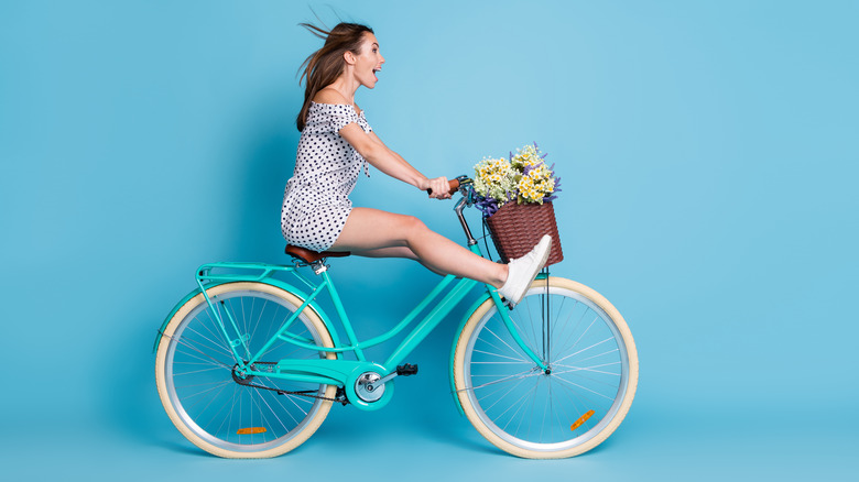 woman riding bike with flowers