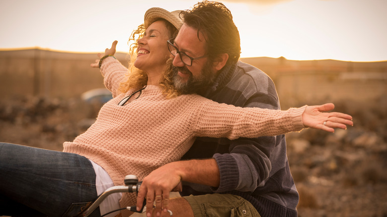 Two people smiling on a bike