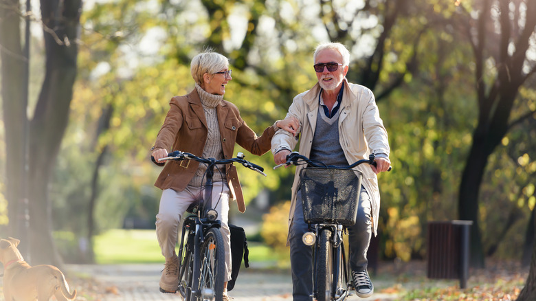 Two elderly people cycling together