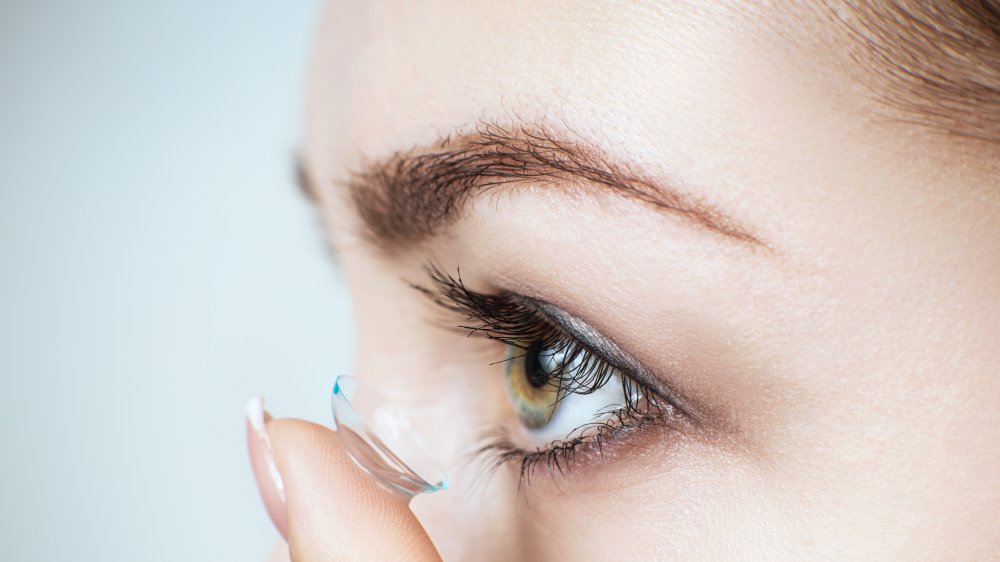 Woman inserting contact lens