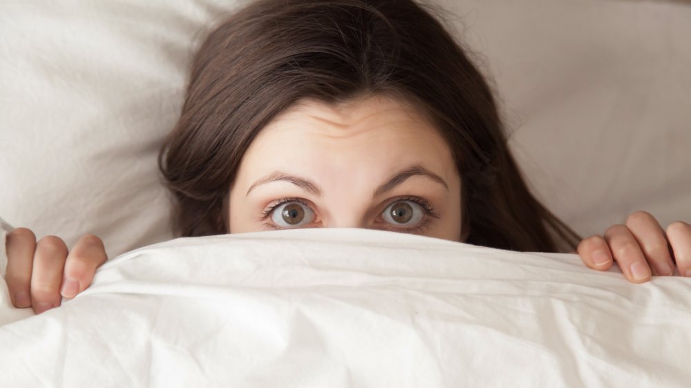 woman with comforter over head