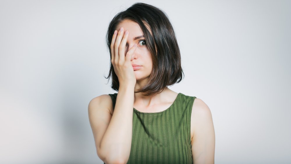 woman covering half of her face