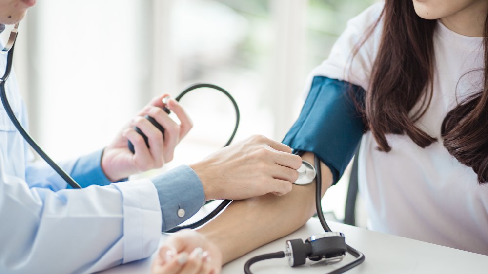 A doctor monitoring a woman's blood pressure