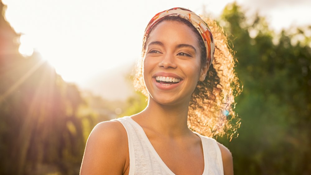 A woman smiling outside in the sunshine