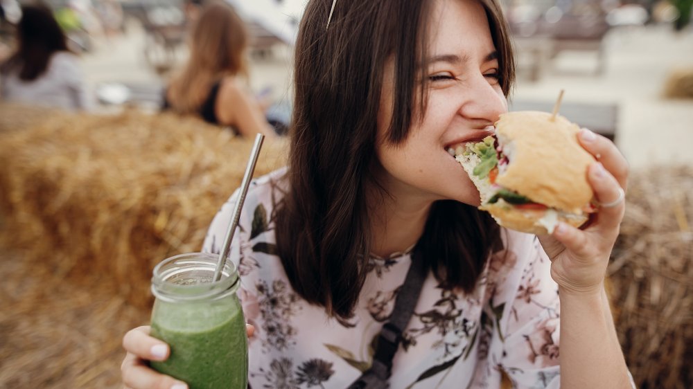 A vegan woman with a burger and a smoothie