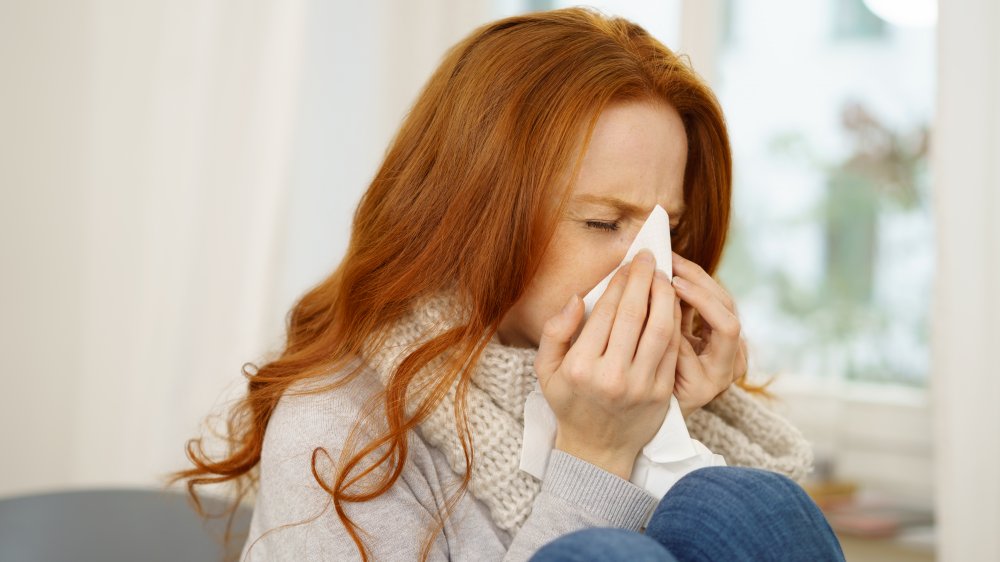 A woman blowing her nose