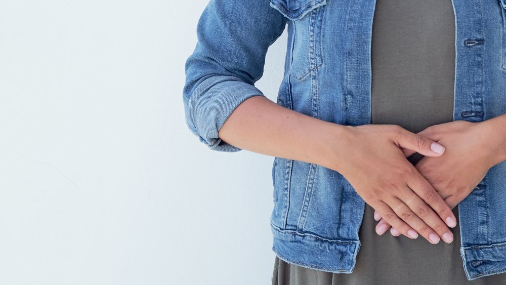 A woman with her hands on her abdomen