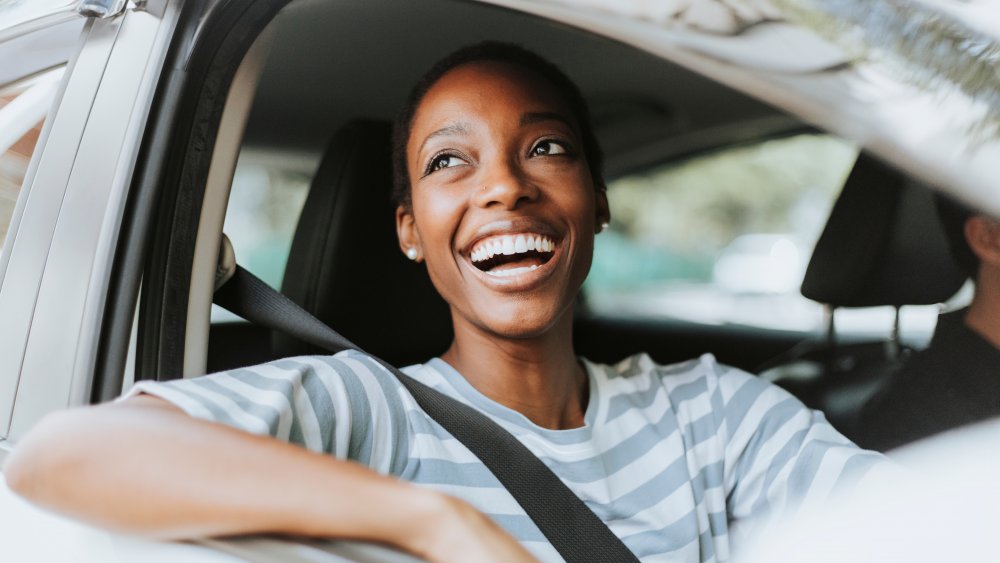 A cheerful woman in a car