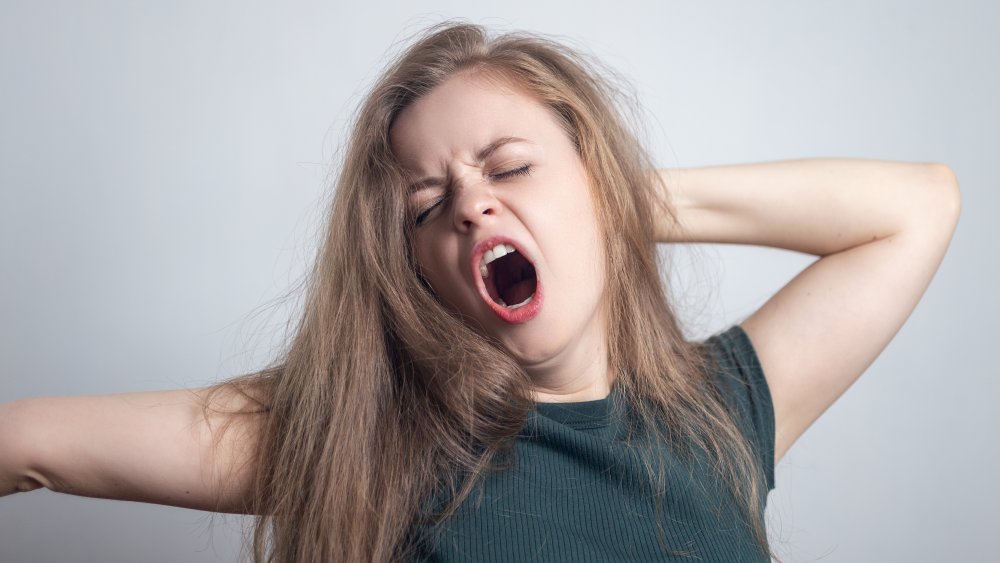 A groggy woman, yawning