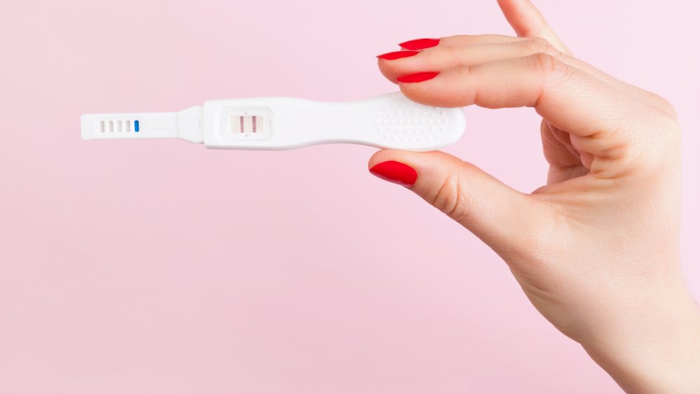 woman holding pregnancy test