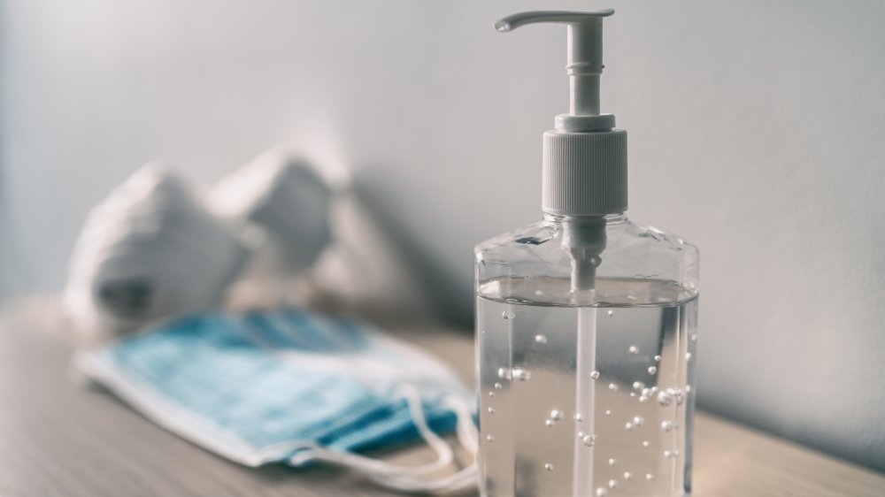 A bottle of hand sanitizer and surgical masks