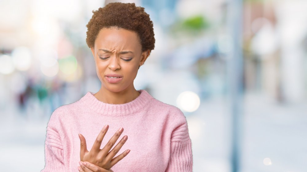 A woman holding her hand in pain